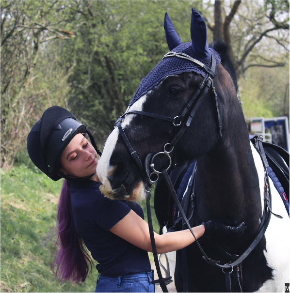 Morgan Dutton with her horse Feather wearing matchy sets of horse accessories including ear bonnets, stirrup covers, browband and girdle