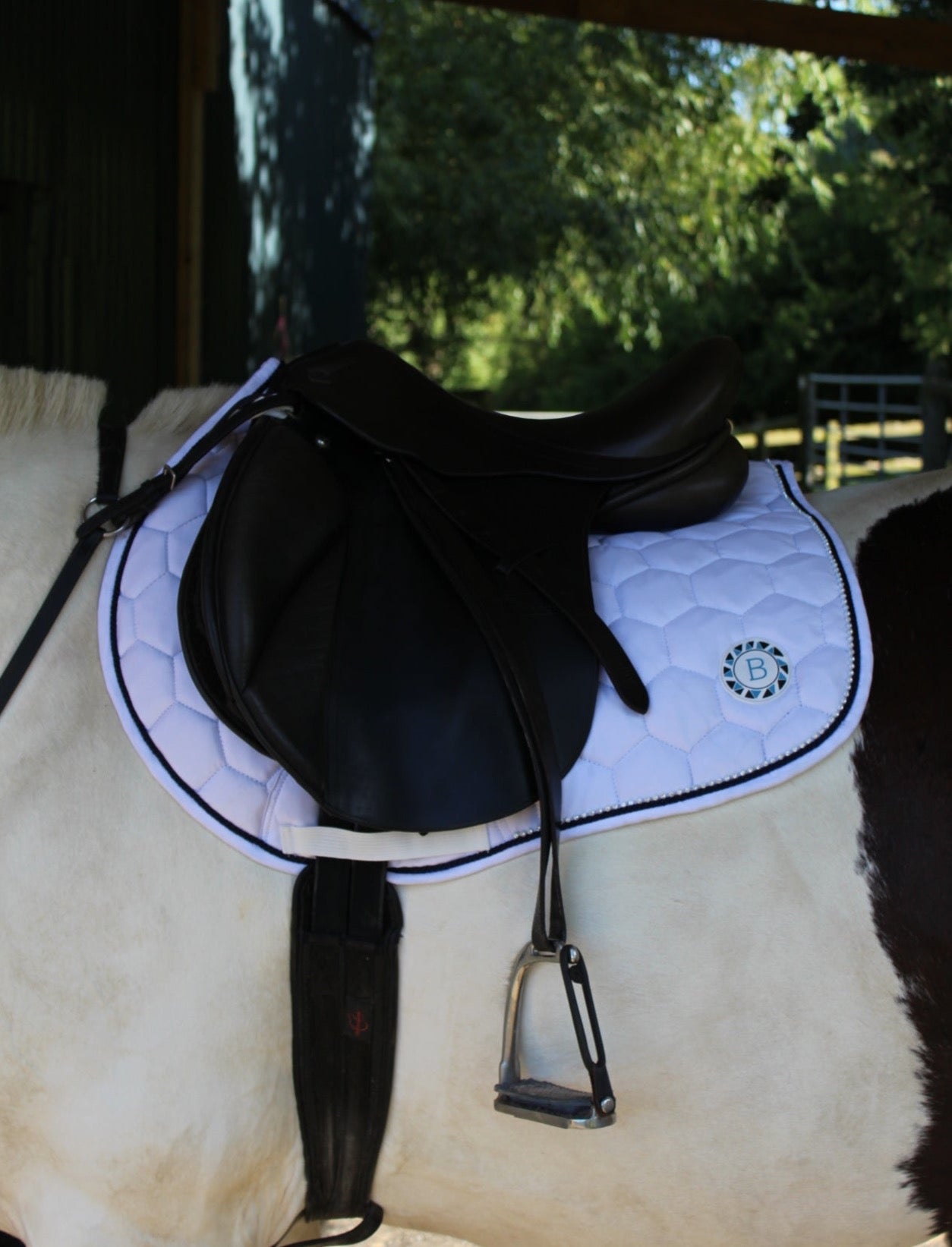 Luxury white cotton competition saddle pad numnah with navy piping and diamontés on it.
