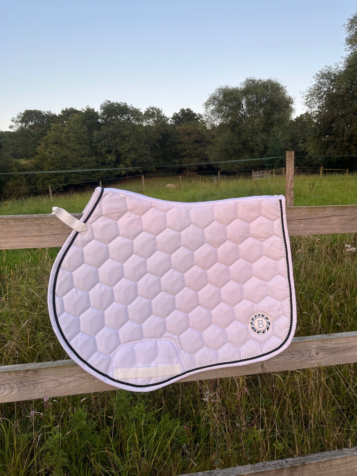 Luxury white cotton competition saddle pad numnah with navy piping and diamontés on it.
