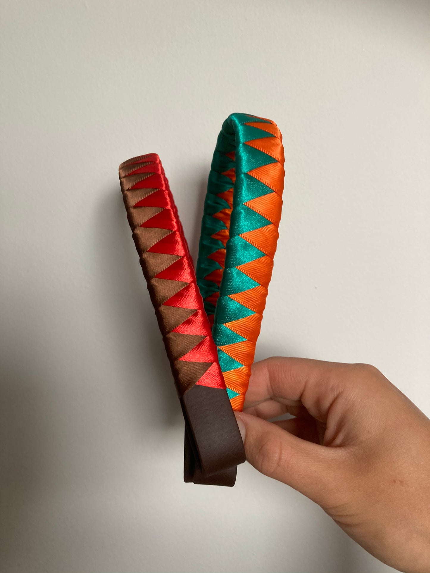 a red and brown and an emerald green and orange bespoke browband