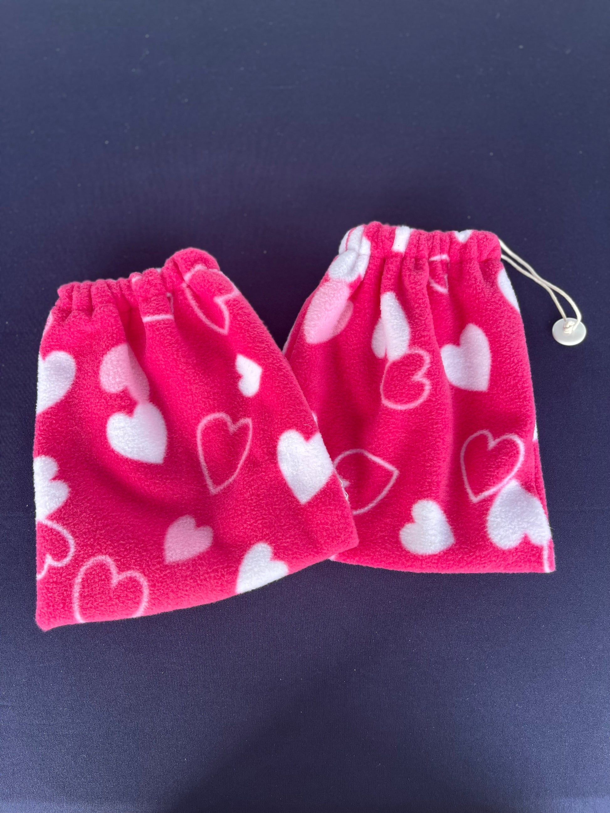 pink stirrup covers with various styles of hearts on them