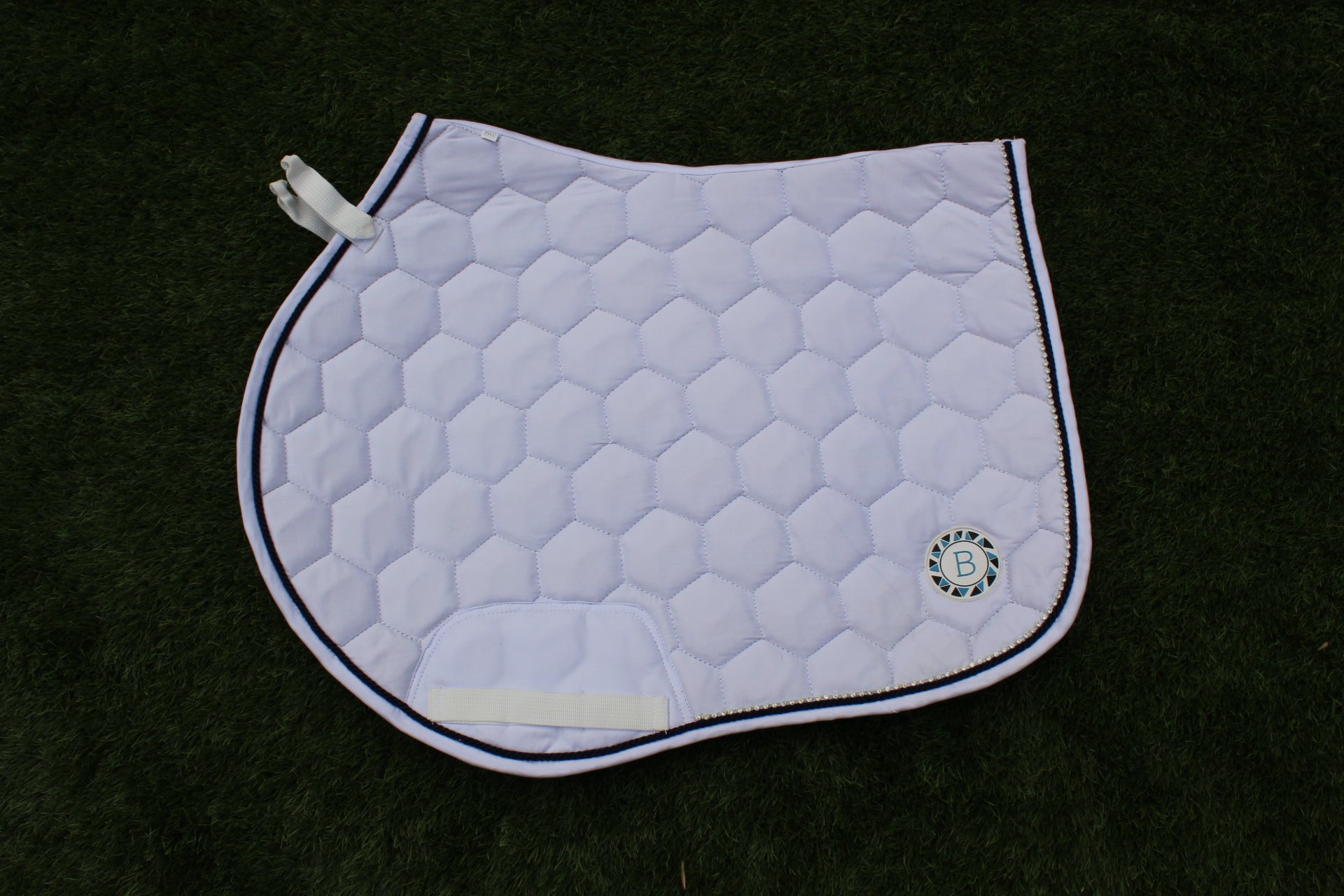 Luxury white cotton competition saddle pad numnah with navy piping and diamontés on it.