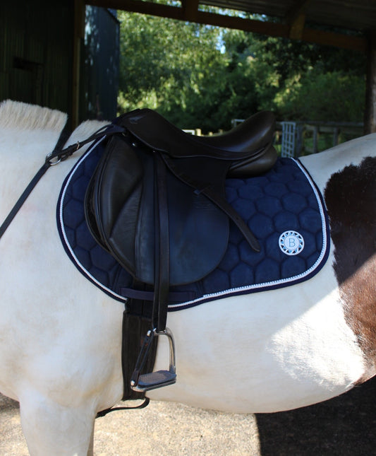 Navy brushed suede competition saddle pad numnah with white piping and diamontés on it.
