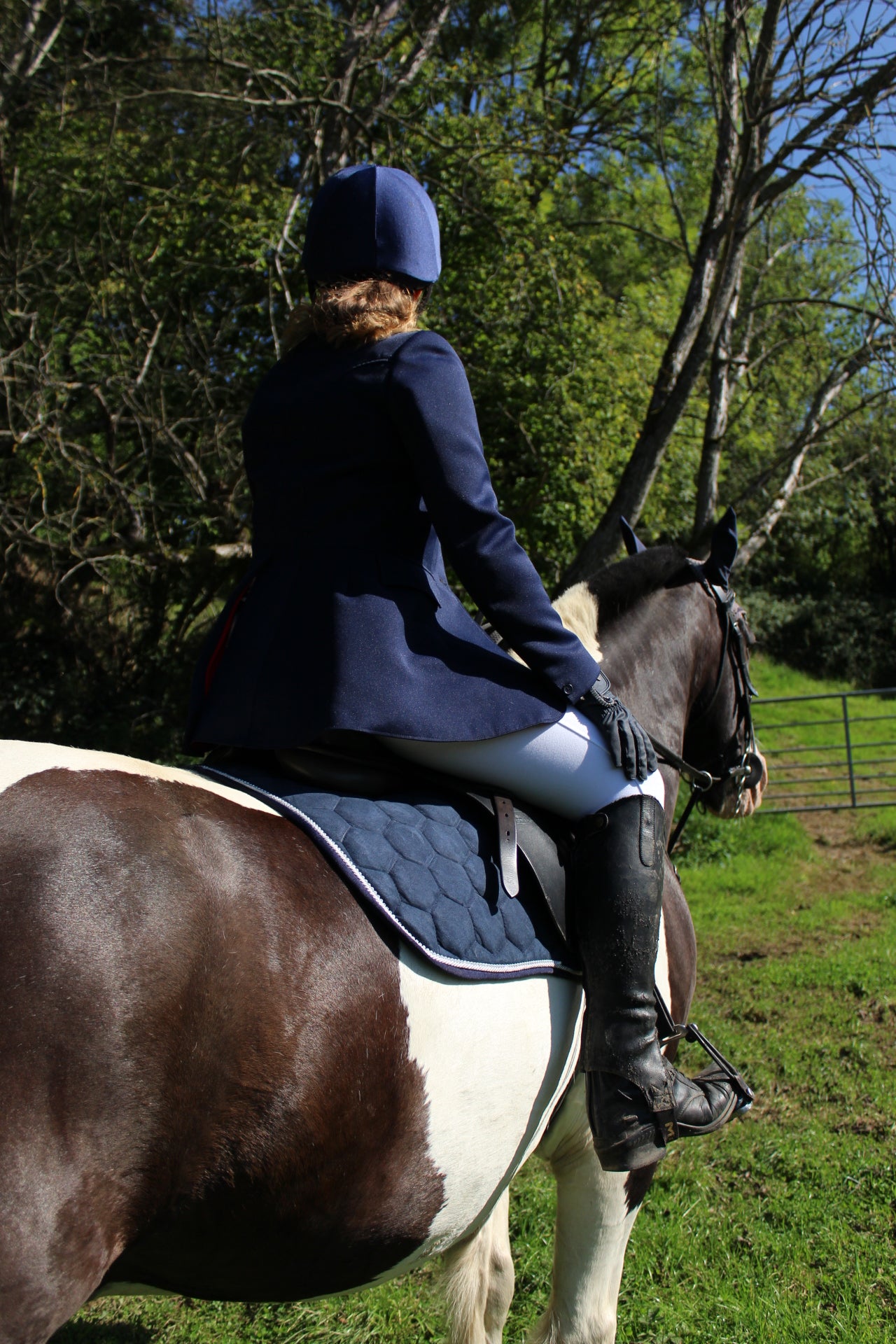 Luxury navy suede competition saddle pad numnah with white piping and diamontés on it.